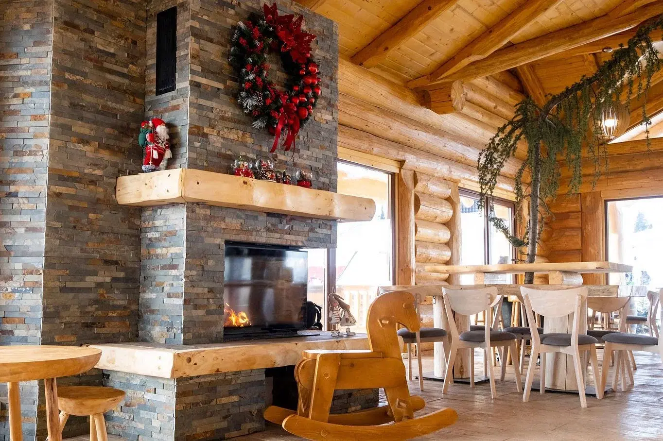 Interiorul Après Ski Luma M3, cu șemineu și mese din lemn